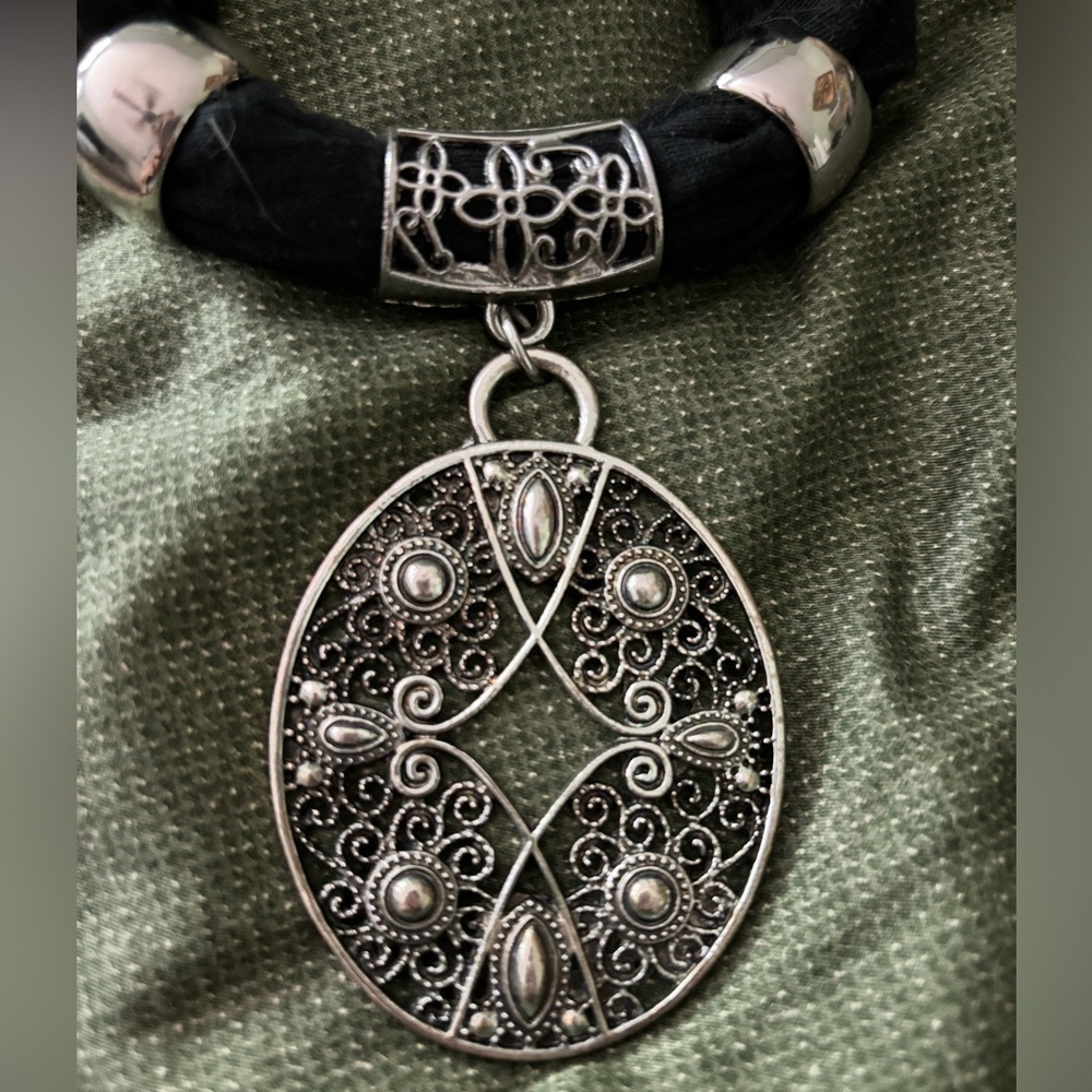 Vintage scarf pendant, oval 2”X 2.5”, with two gold tone rings.